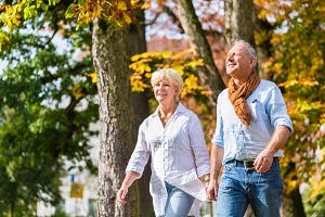 Older couple walking in a park on an autumn day