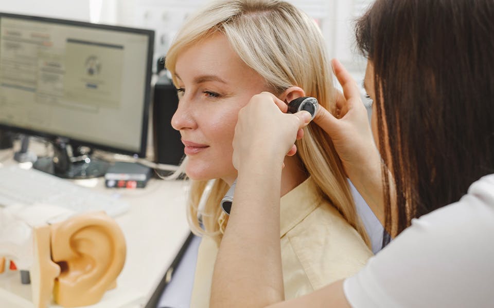 A woman having a hearing check-up with an audiologist